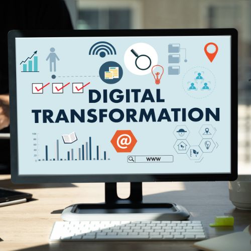 Photo of PC with graphics on top and the word digital transformation 